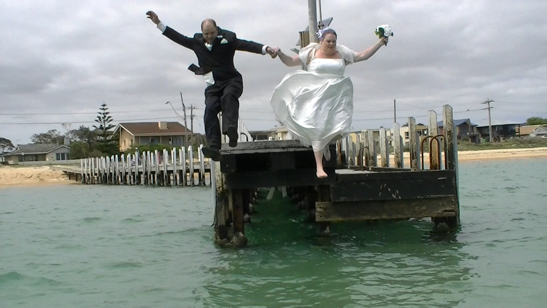 Wedding Couple jump into ocean
